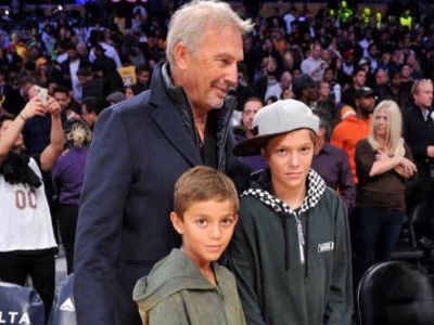 Cayden and Hayes Costner are in a hoodie looking at the camera while Kevin Costner is looking somewhere else.